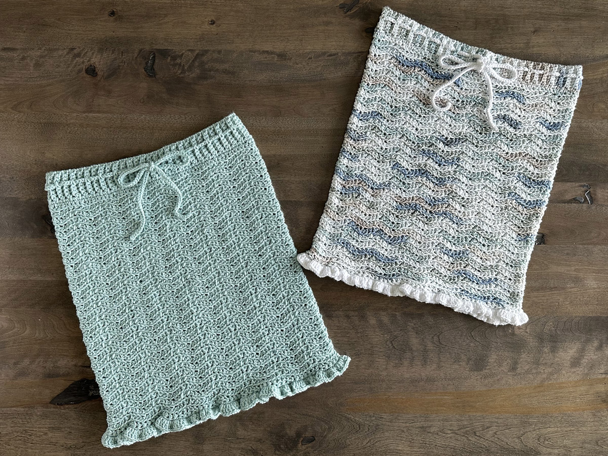 Two ripple pattern crocheted pencil skirts displayed on a wood background.
